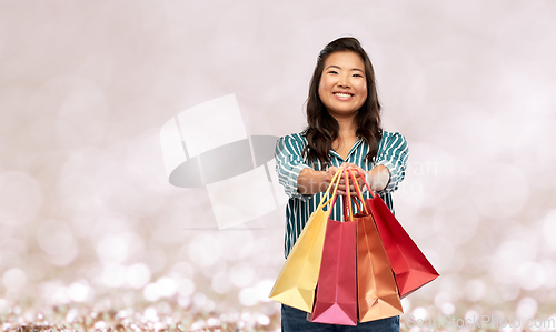 Image of happy asian woman with shopping bags