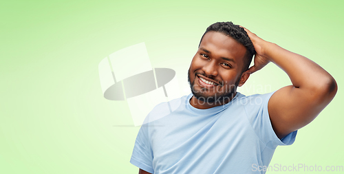 Image of happy african american man touching his hair