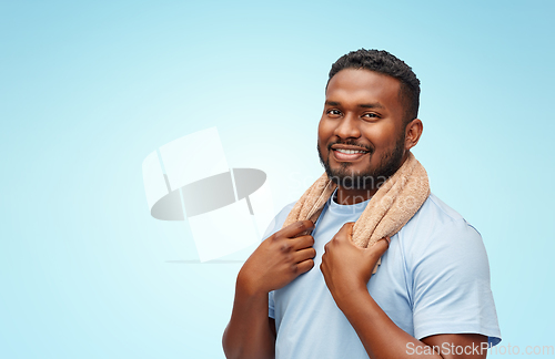 Image of smiling african man with bath towel over blue