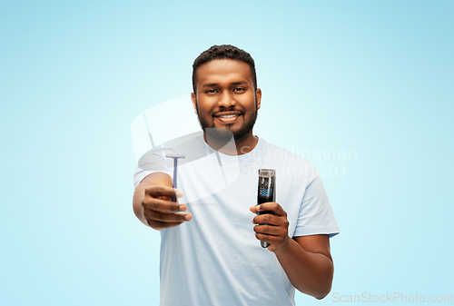 Image of smiling african man with razor blade and trimmer