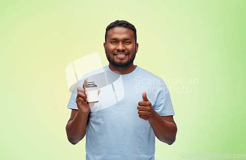 Image of happy african man with medicine showing thumbs up