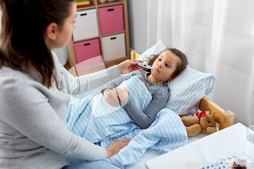 Image of mother and sick daughter measuring temperature