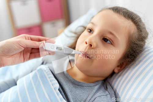 Image of mother and sick daughter measuring temperature