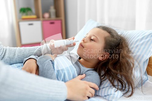 Image of mother with nasal spray treats sick daughter