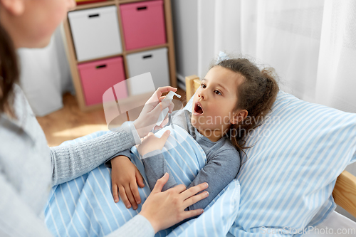 Image of mother with oral spray treats sick little daughter