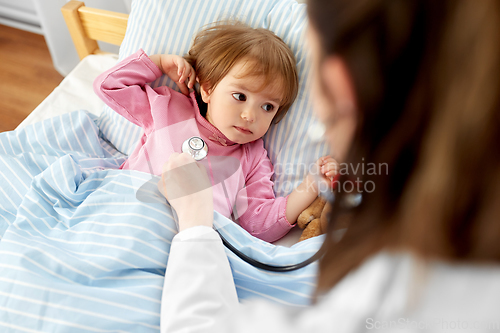 Image of doctor with stethoscope and sick girl in bed