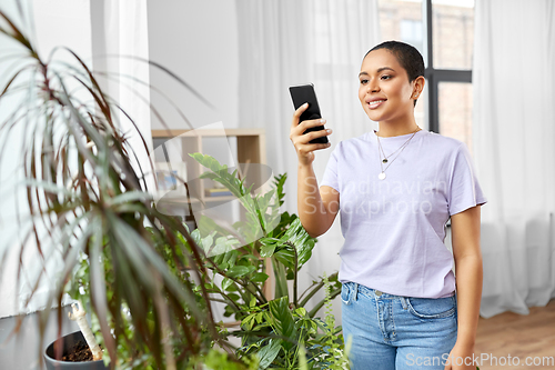 Image of african american woman with smartphone at home