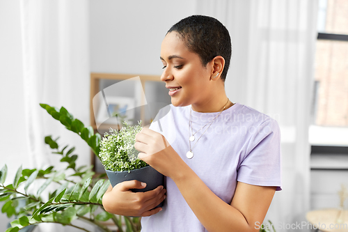 Image of african american woman with plants at home