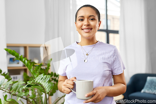Image of african american woman drinking coffee at home
