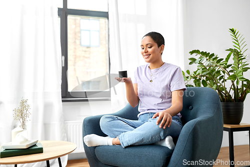 Image of african american woman with smart speaker at home