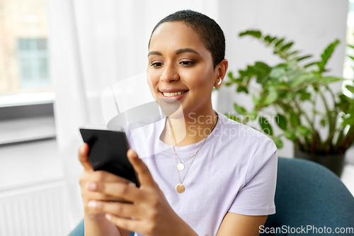 Image of african american woman with smartphone at home