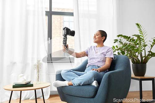 Image of female blogger with camera video blogging at home