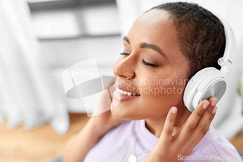 Image of woman in headphones listening to music at home
