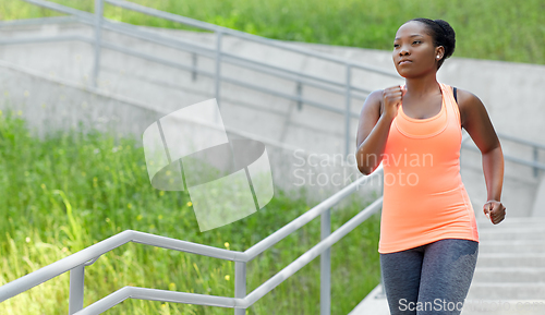 Image of young african american woman running downstairs