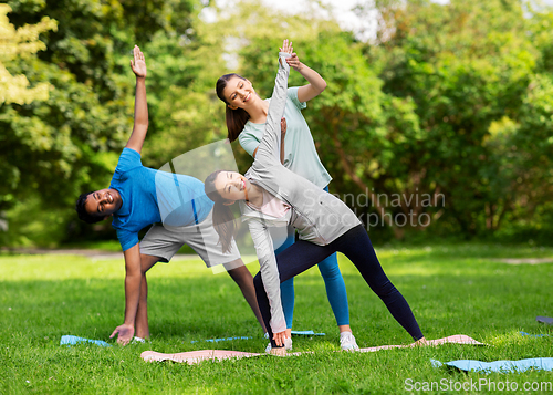 Image of group of happy people doing yoga at summer park