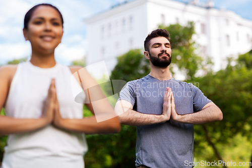 Image of group of people doing yoga at summer park