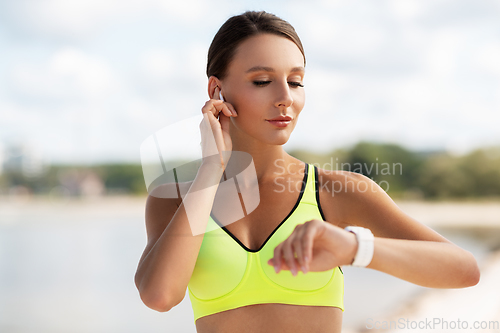 Image of woman with earphones and smart watch doing sports