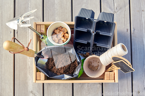 Image of garden tools, soil and pots in wooden box