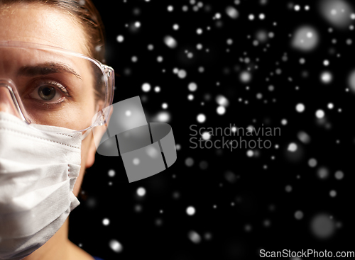 Image of female doctor or nurse in goggles and face mask