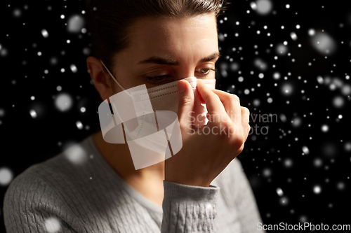 Image of sick woman adjusting protective medical face mask