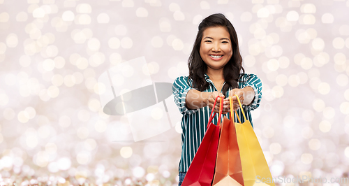 Image of happy asian woman with shopping bags