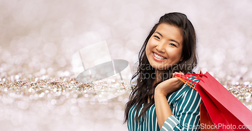 Image of happy asian woman with shopping bags