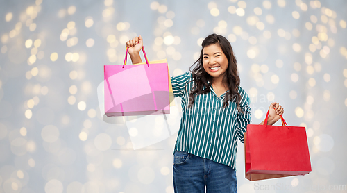 Image of happy asian woman with shopping bags