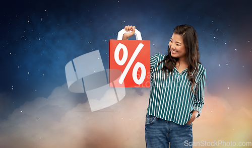 Image of asian woman with percentage sign on shopping bags