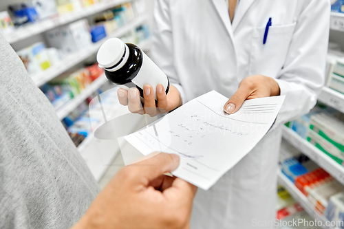 Image of pharmacist and customer with medicine at pharmacy