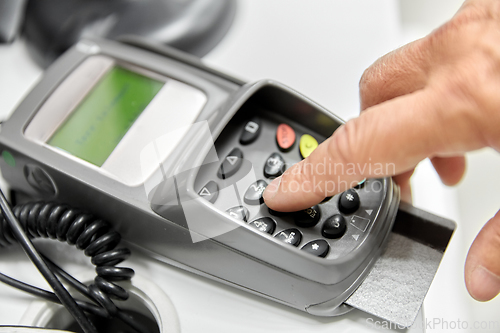 Image of close up of hand with credit card in card-reader