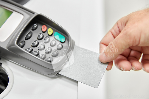 Image of close up of hand with credit card in card-reader