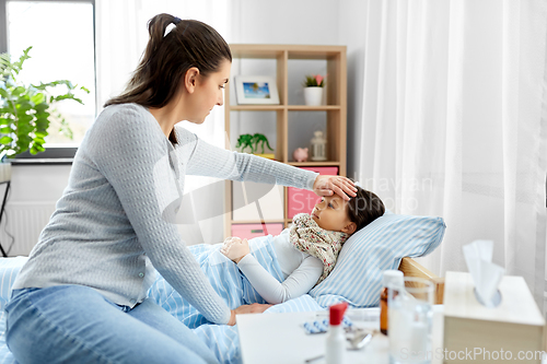 Image of mother measuring temperature of sick daughter