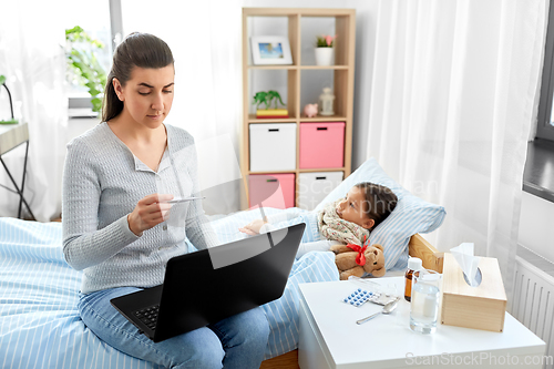 Image of ill daughter and mother with laptop at home