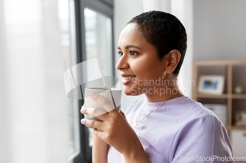 Image of happy woman with coffee looking out of window