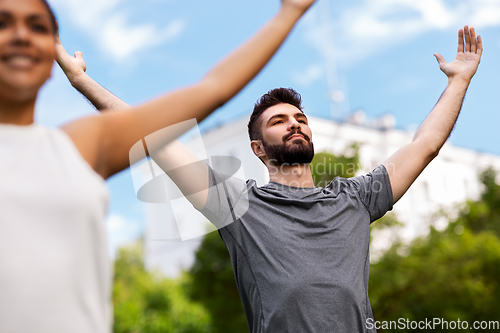 Image of group of people doing yoga at summer park