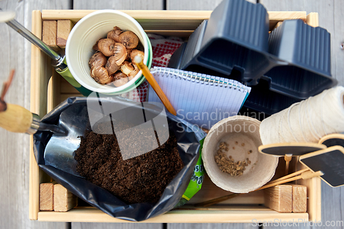 Image of garden tools, soil and pots in wooden box