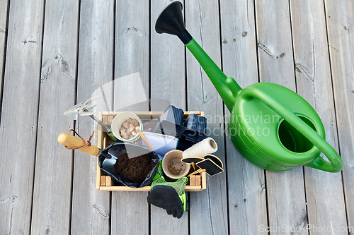 Image of box with garden tools and watering can in summer