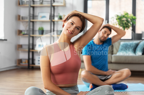 Image of happy couple exercising at home