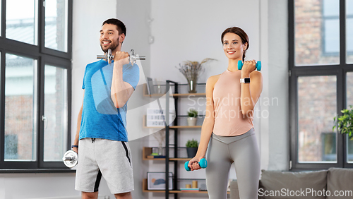 Image of happy couple exercising at home