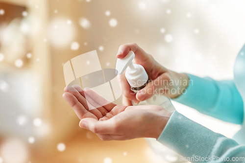 Image of close up of woman applying hand sanitizer