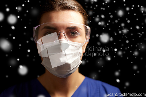 Image of female doctor or nurse in goggles and face mask