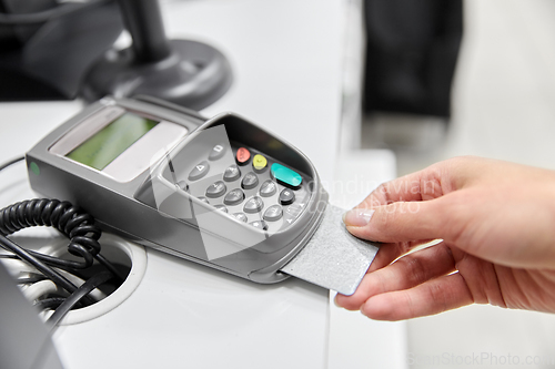 Image of close up of hand with credit card in card-reader