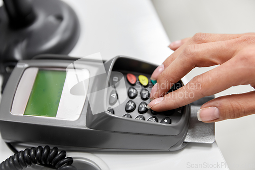 Image of close up of hand with credit card in card-reader