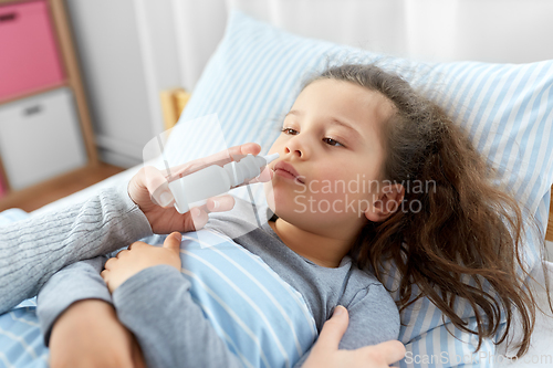 Image of mother with nasal spray treats sick daughter