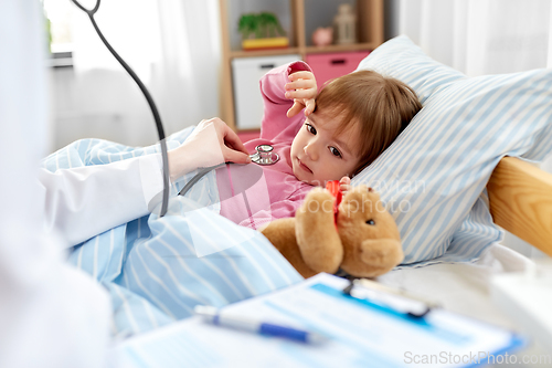 Image of doctor with stethoscope and sick girl in bed