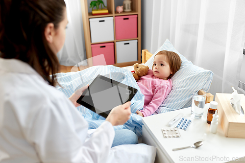 Image of doctor with tablet pc and sick girl in bed at home