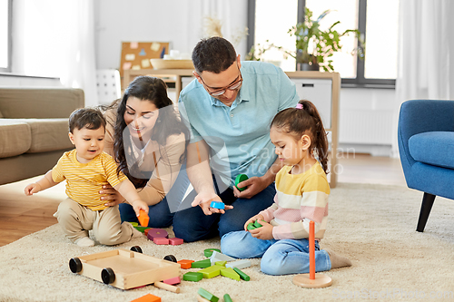 Image of happy family palying with wooden toys at home