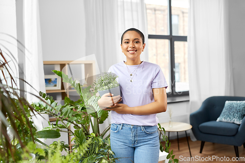 Image of african american woman with plants at home