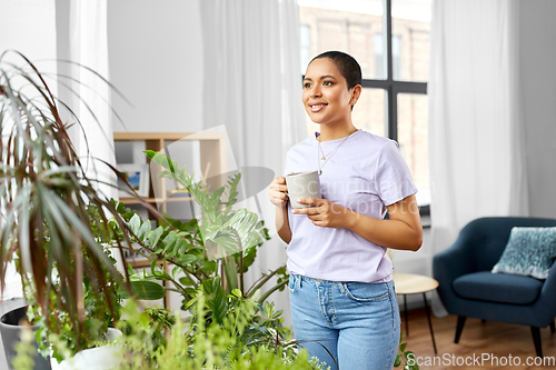 Image of african american woman drinking coffee at home