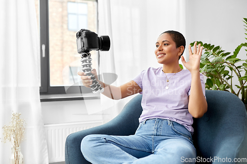 Image of female blogger with camera video blogging at home